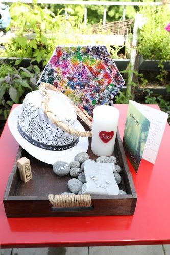 Kiste mit Memorabilia für Sebastian, u.a. Hut, Kerze, Steine