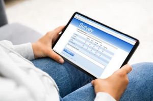 Oberschenkel einer Person mit Tablet, auf dem eine Umfrage zu sehen ist
